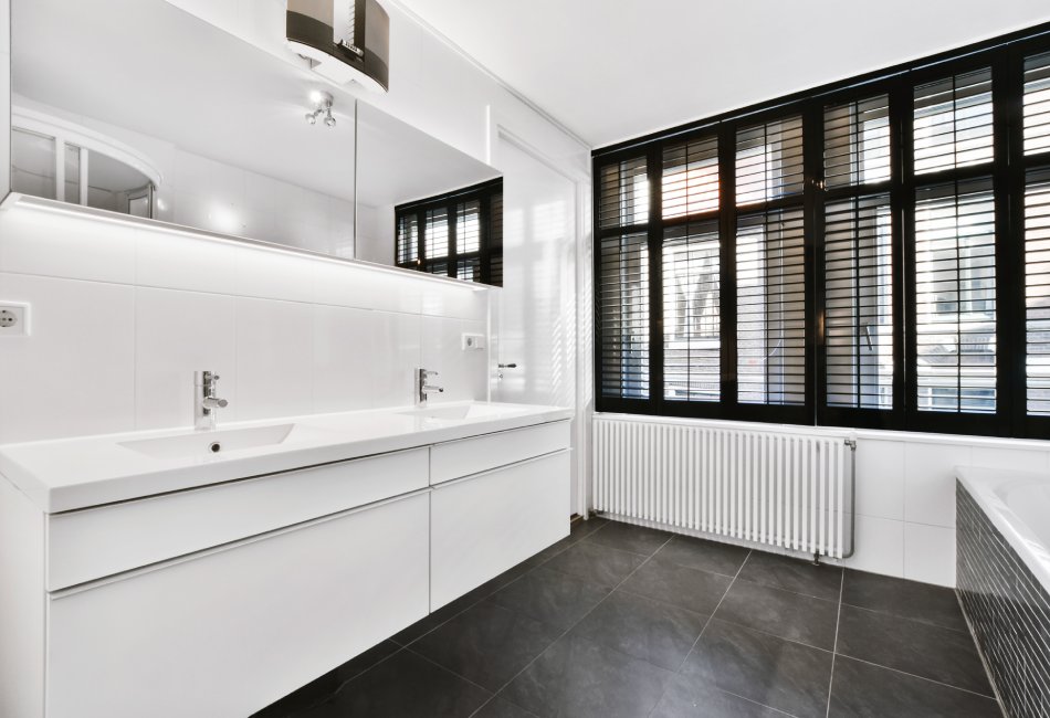 Soluciones de mobiliario de cocina y baño en Castellón MVSM para constructores e interioristas. Amplio baño con muebles blancos.